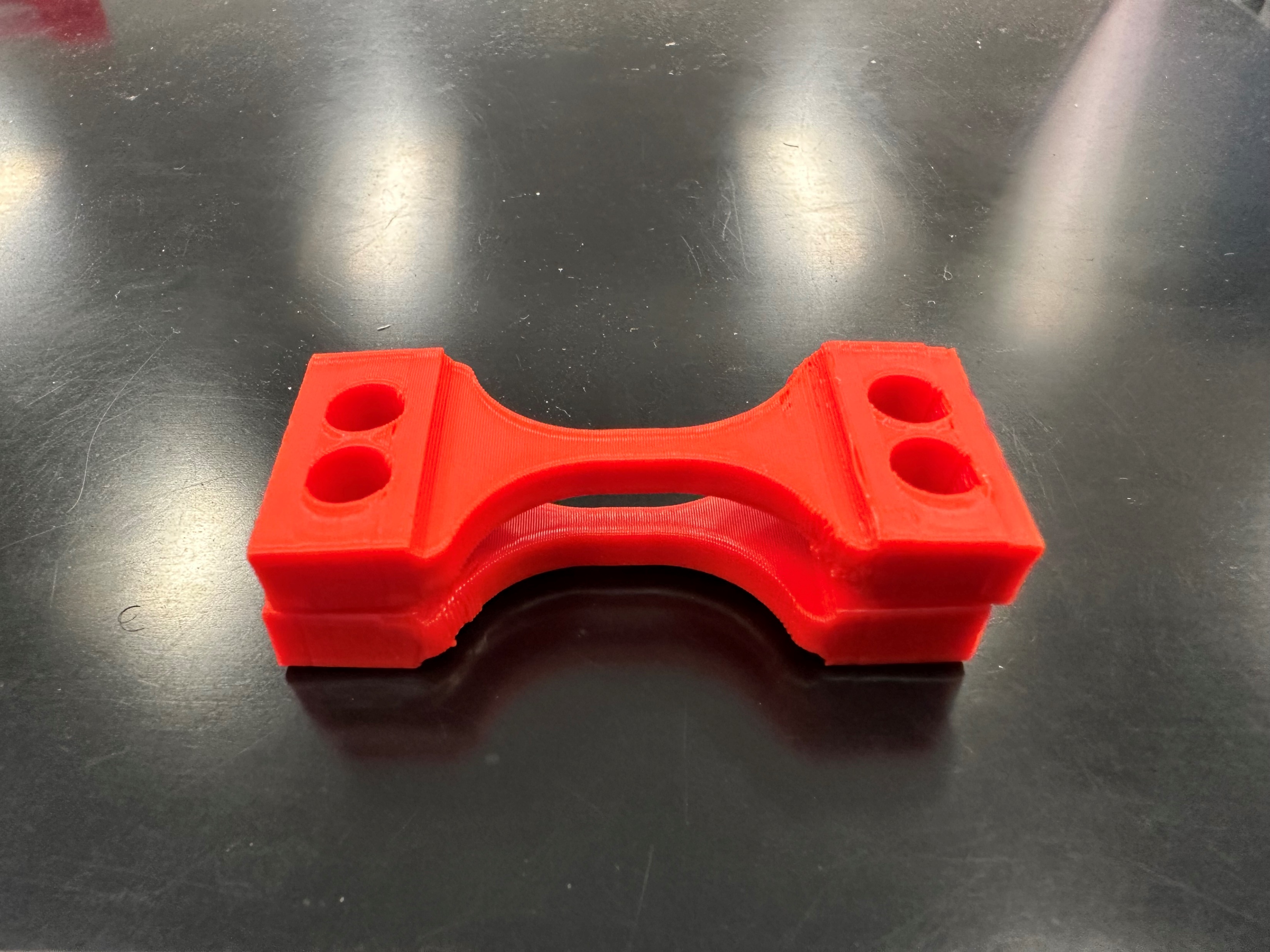 3D printed red PLA dog-bone tensile specimen — 100% infill, 0.2mm layers