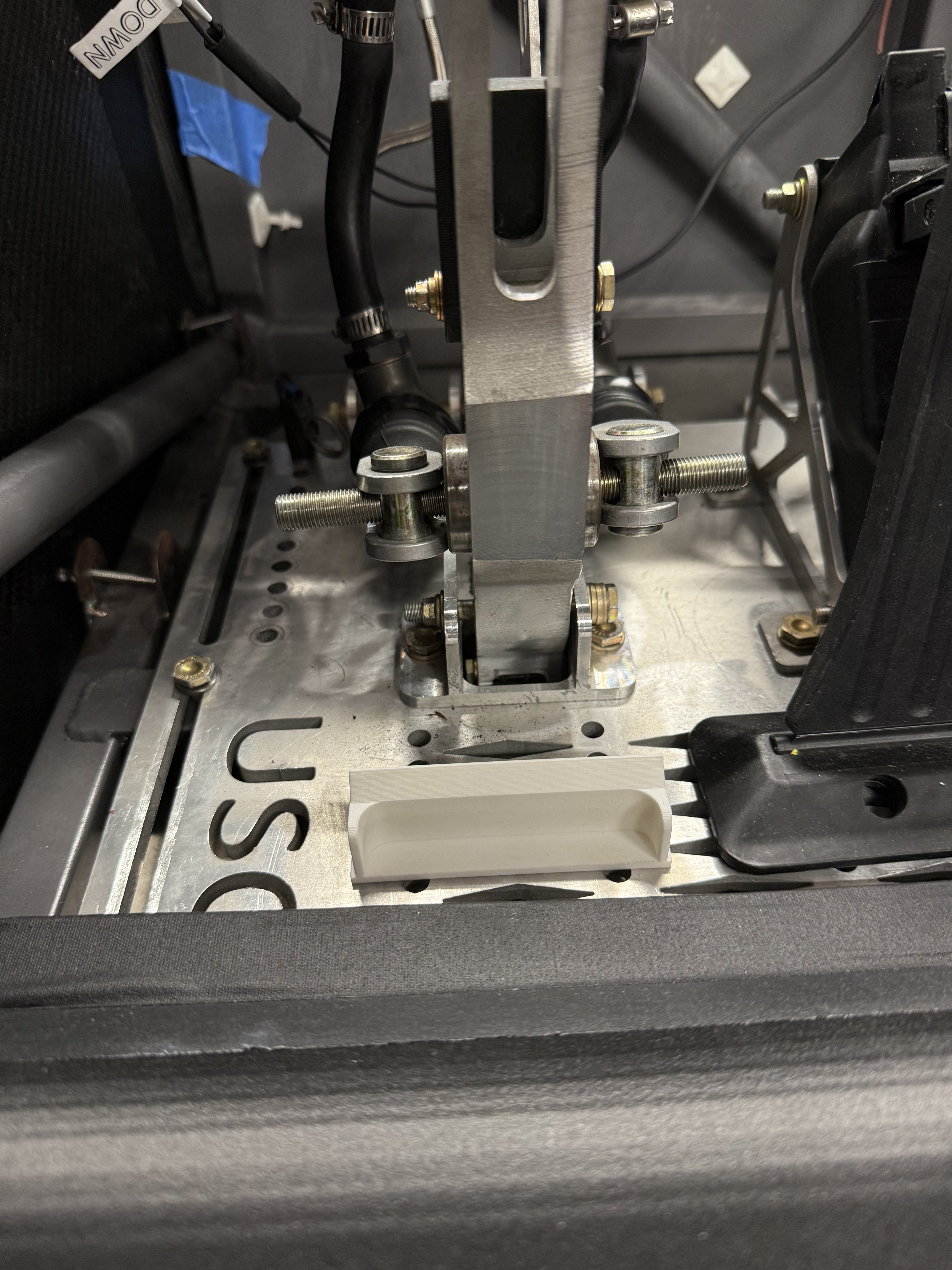 Interior cockpit — full pedal box view with steering column and USC plate