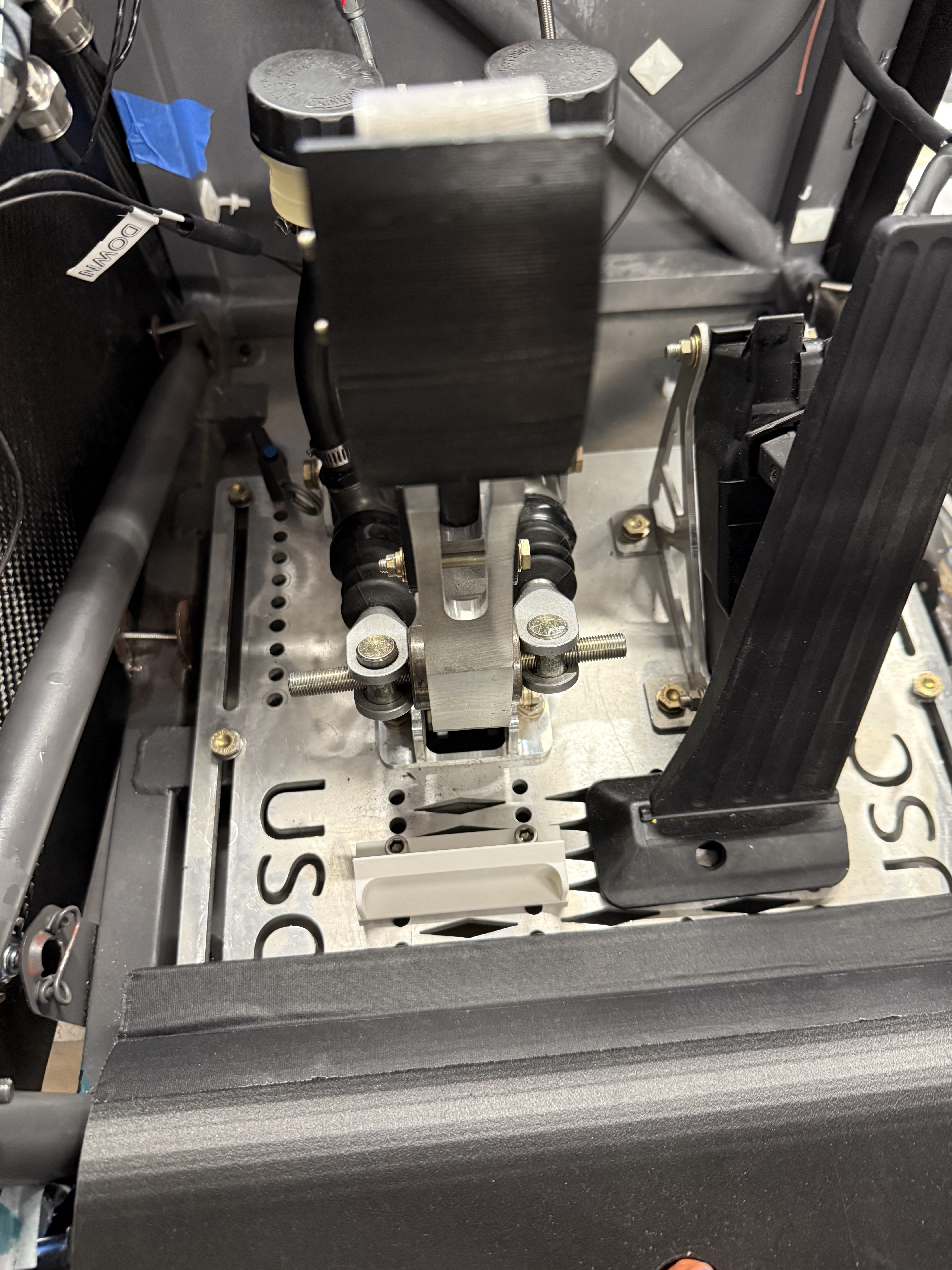 Pedal box assembly installed in cockpit — brake master cylinders and balance bar